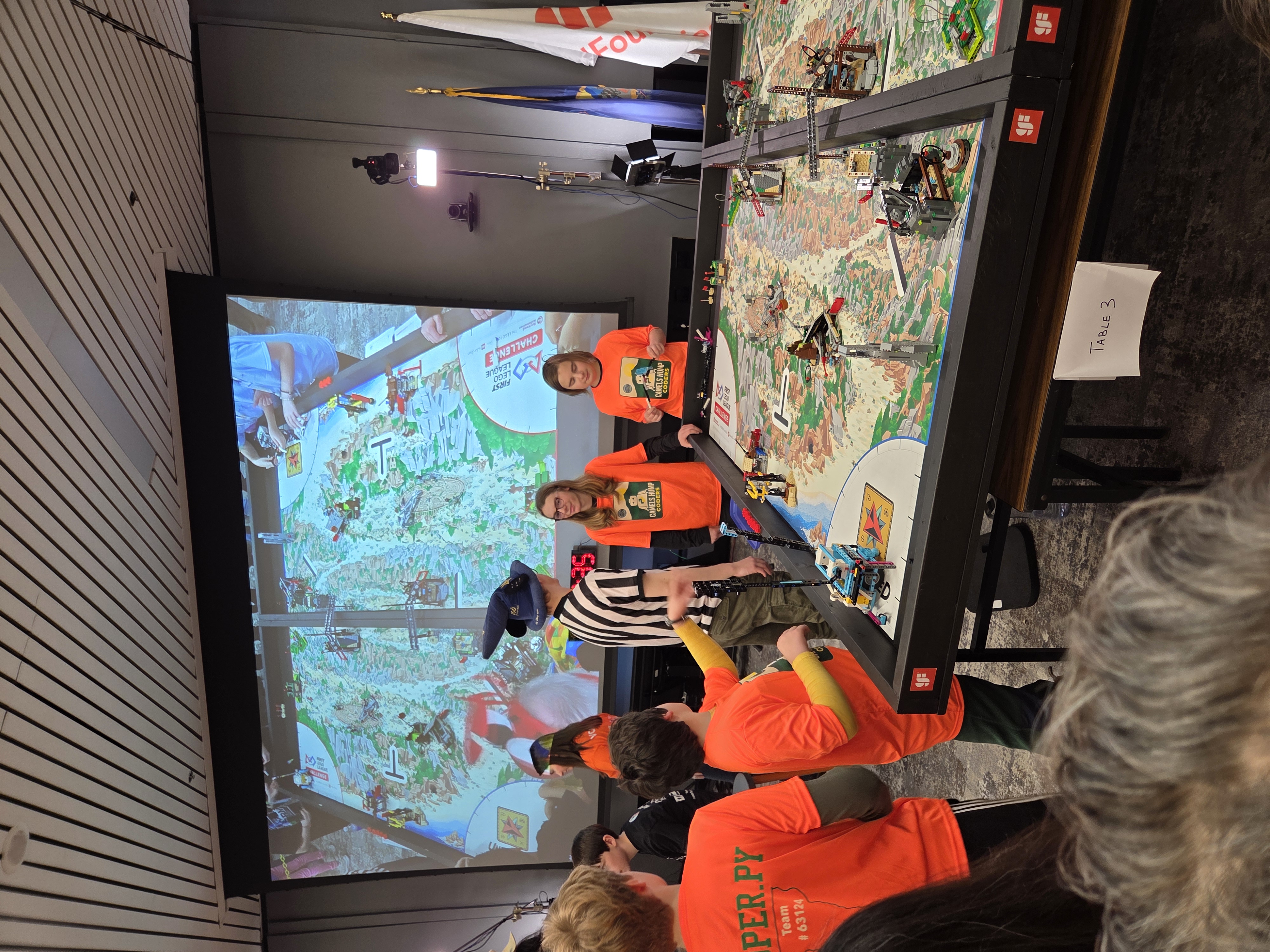 Team members watching their robot at an FLL game table