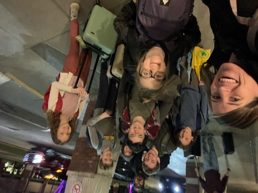 Team members and supporters posing together outdoors at night