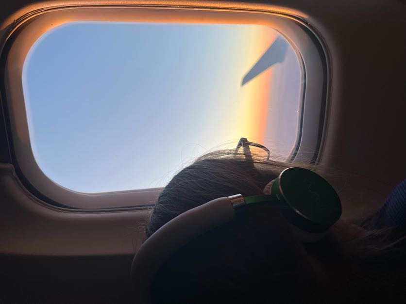 View of the sunset and an airplane wing from a passenger window