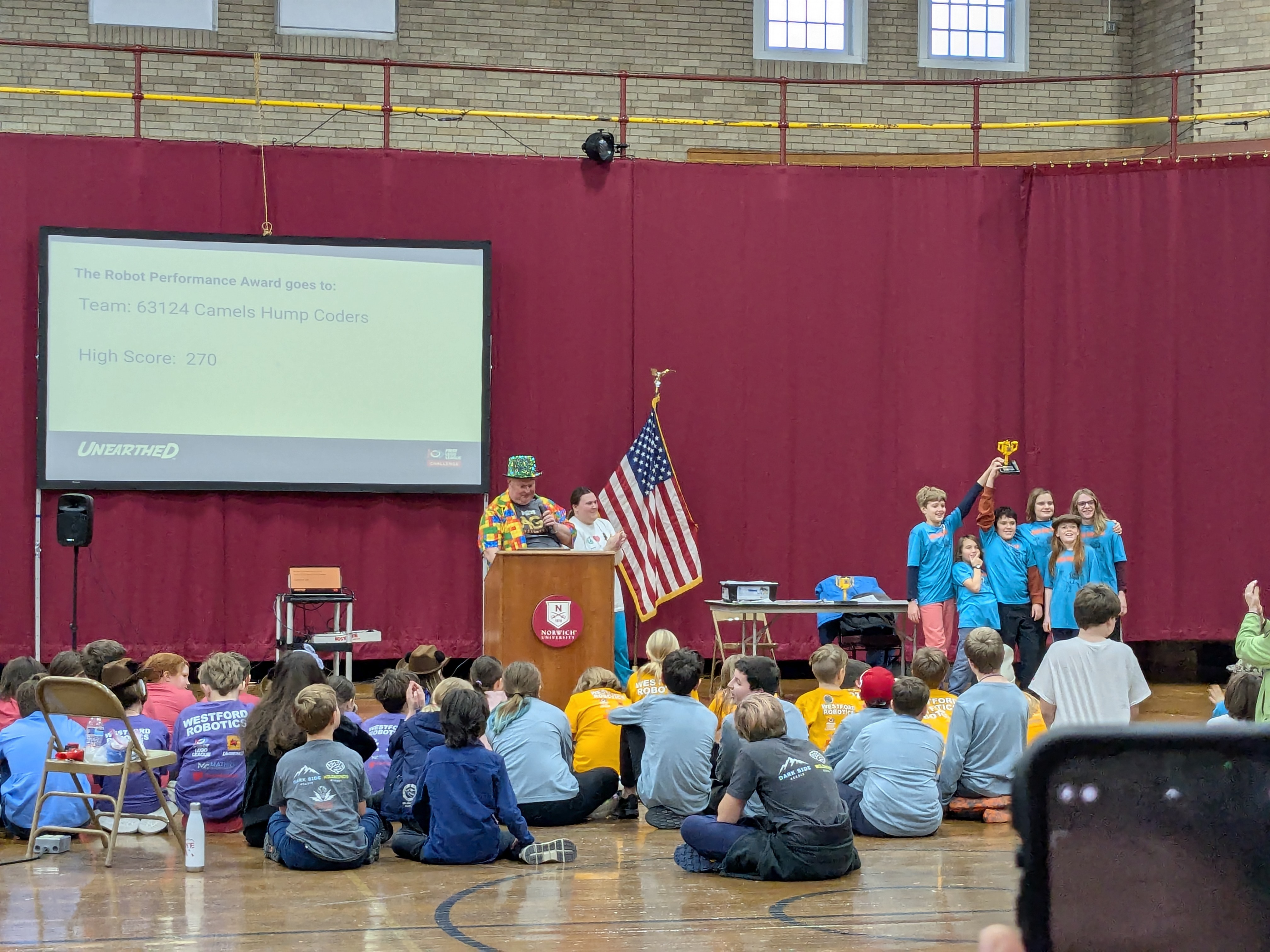 Students seated in a gym during an FLL competition ceremony