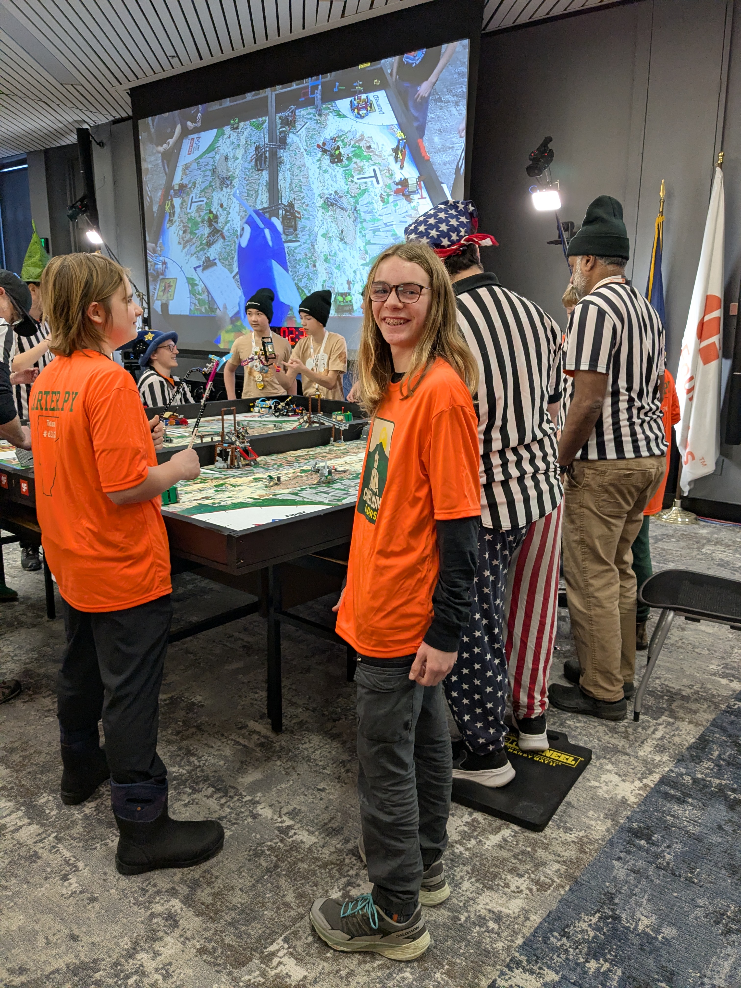 Team members and referees around an FLL robot game table